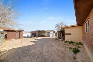 View of side of home with a shed and a carport