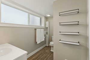 Bathroom with a textured ceiling, toilet, vanity, and hardwood / wood-style floors