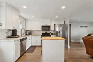 Kitchen featuring white cabinetry, a kitchen island, and stainless steel appliances