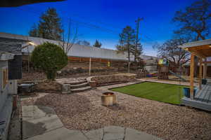 View of yard with a playground and a fenced backyard