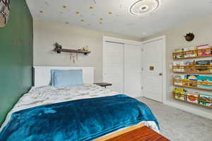 Bedroom featuring light carpet and a closet