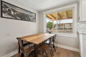 Dining area featuring hardwood / wood-style floors and a textured ceiling