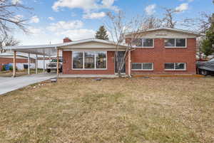 View of front of home featuring a front lawn and a carport