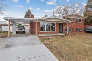 View of front of house with a carport and a front yard