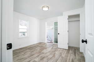 Unfurnished bedroom with light hardwood / wood-style flooring and a closet