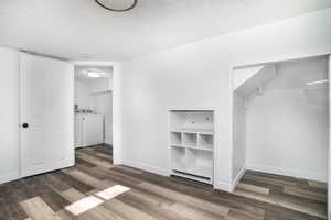 Interior space featuring dark hardwood / wood-style floors, washer and clothes dryer, and a textured ceiling