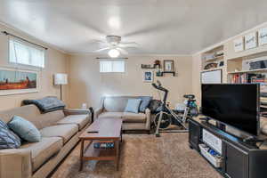 Living room with ceiling fan, carpet flooring, and a healthy amount of sunlight