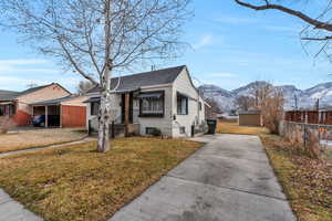 Bungalow-style house featuring a shed, a mountain view, and a front lawn