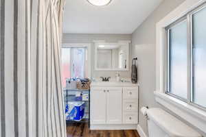 Bathroom featuring toilet, hardwood / wood-style flooring, and vanity