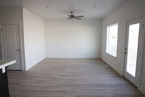 Empty room featuring light wood-type flooring and ceiling fan