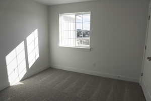 Spare room featuring dark carpet