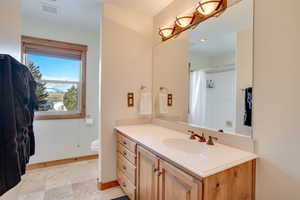 Bathroom featuring vanity, toilet, and a shower with shower curtain