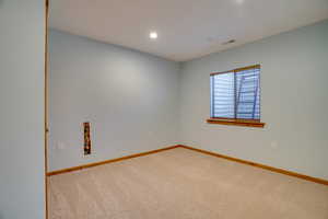 Unfurnished room featuring light colored carpet