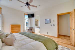 Bedroom featuring ceiling fan, connected bathroom, and light hardwood / wood-style floors