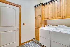 Laundry room with separate washer and dryer and cabinets