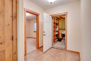 Corridor with light tile patterned flooring