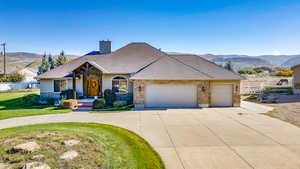 View of front of property with a mountain view, a garage, and a front yard