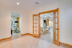 Interior space with french doors and light tile patterned flooring