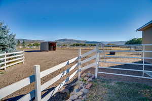 View of yard featuring an outdoor structure, a mountain view, and a rural view