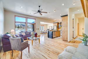 Living room featuring a textured ceiling, light hardwood / wood-style flooring, and ceiling fan