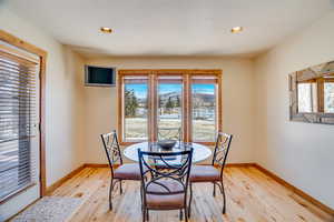 Dining area with light hardwood / wood-style floors and a textured ceiling