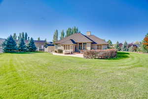 Back of house featuring a yard and a patio area