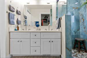 Bathroom featuring vanity and a tile shower