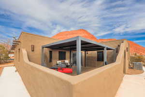 Rear view of property featuring central AC unit, a mountain view, and a patio area