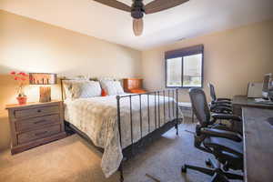 Carpeted bedroom with a ceiling fan and visible vents