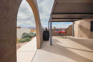 View of patio / terrace featuring fence, a mountain view, and outdoor dining area