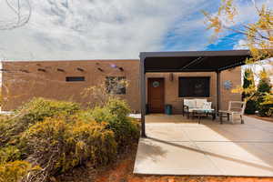 Exterior space with an outdoor living space, stucco siding, and a patio area