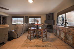 Dining space featuring light tile patterned floors and a fireplace