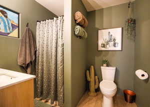 Bathroom with tile patterned floors, vanity, toilet, and a shower with shower curtain