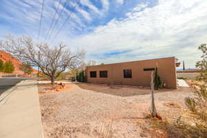 View of property exterior featuring stucco siding and fence