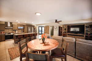 Dining space featuring a ceiling fan and light tile patterned flooring