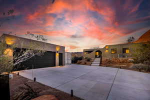 View of front of house with a garage, a gate, and stucco siding