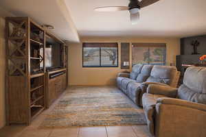 Living room featuring a ceiling fan and light tile patterned flooring