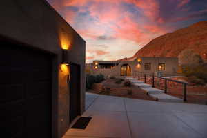 View of front facade featuring a garage, a mountain view, and stucco siding