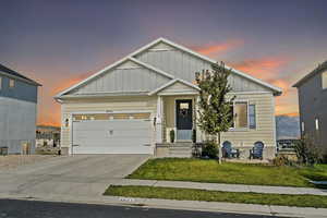 View of front of house featuring a garage and a lawn