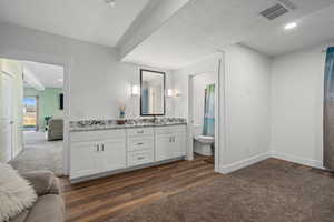 Bathroom with vanity, toilet, a textured ceiling, and hardwood / wood-style floors