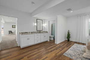 Bathroom with toilet, vanity, and hardwood / wood-style floors