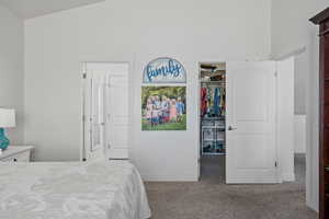 Carpeted bedroom featuring a spacious closet and a closet