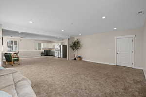 Living room featuring sink, carpet, and a textured ceiling