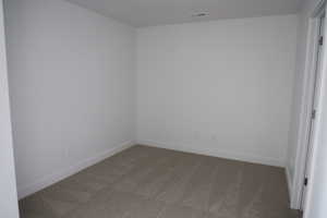 Carpeted spare room with visible vents and baseboards