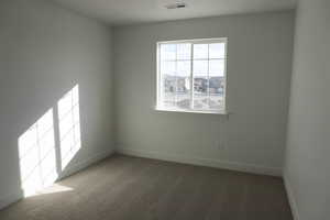 Unfurnished room featuring baseboards, visible vents, and carpet