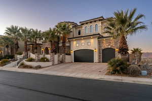 Mediterranean / spanish-style home featuring a tiled roof, concrete driveway, stone siding, stucco siding, and a garage