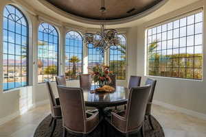 Dining room with baseboards, visible vents, a tray ceiling, and an inviting chandelier