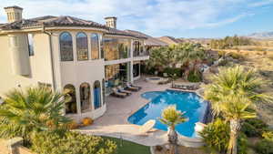 Back of property featuring stucco siding, a tiled roof, an outdoor fire pit, a patio, and a balcony