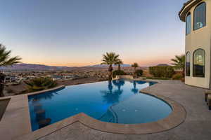 View of swimming pool with a mountain view, an infinity pool, and a patio area