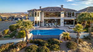 Back of house with a fenced in pool, a balcony, a tiled roof, a patio area, and stucco siding